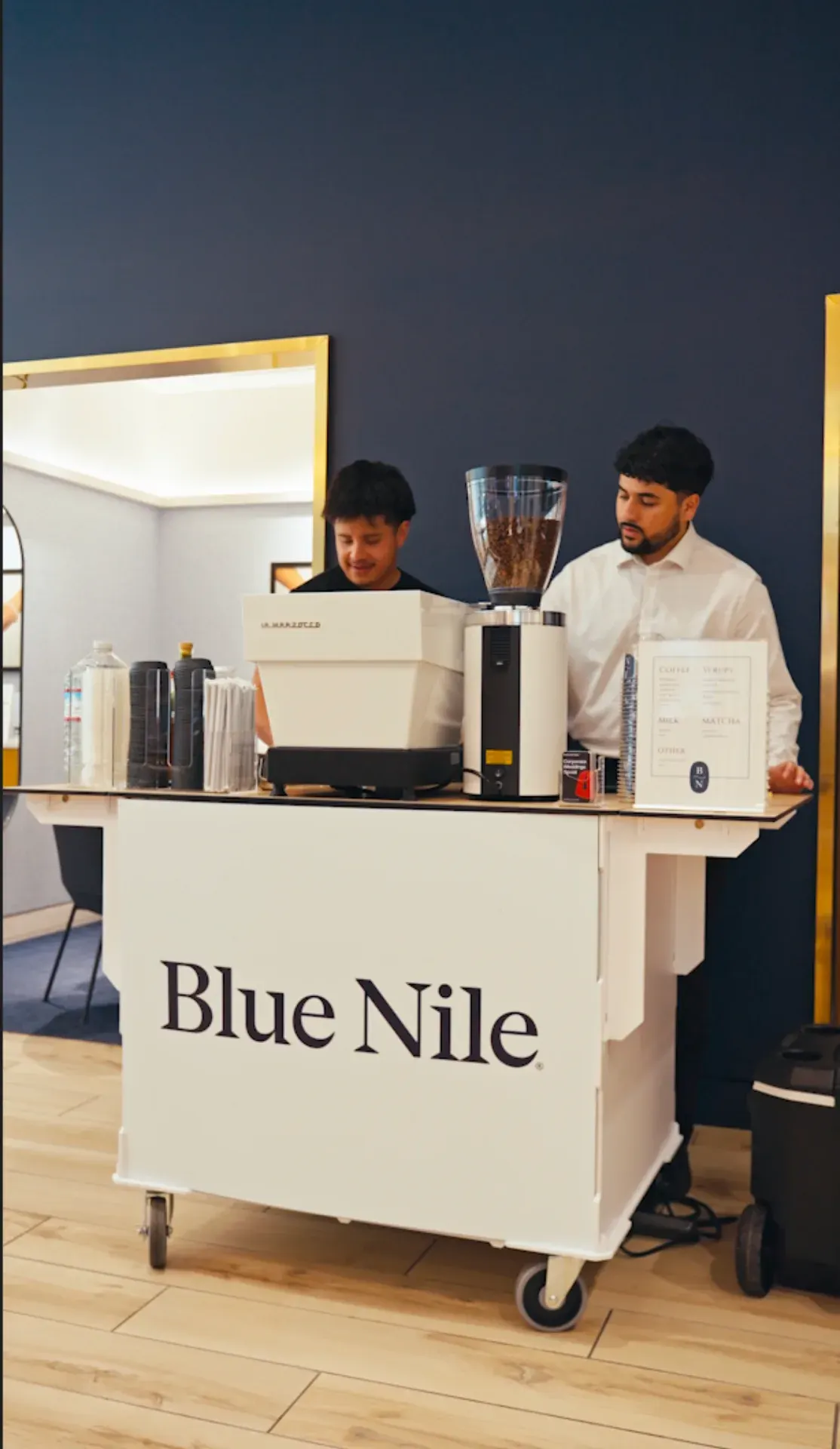 Fez Coffee baristas operating a Blue Nile branded espresso cart at the grand opening in San Francisco.